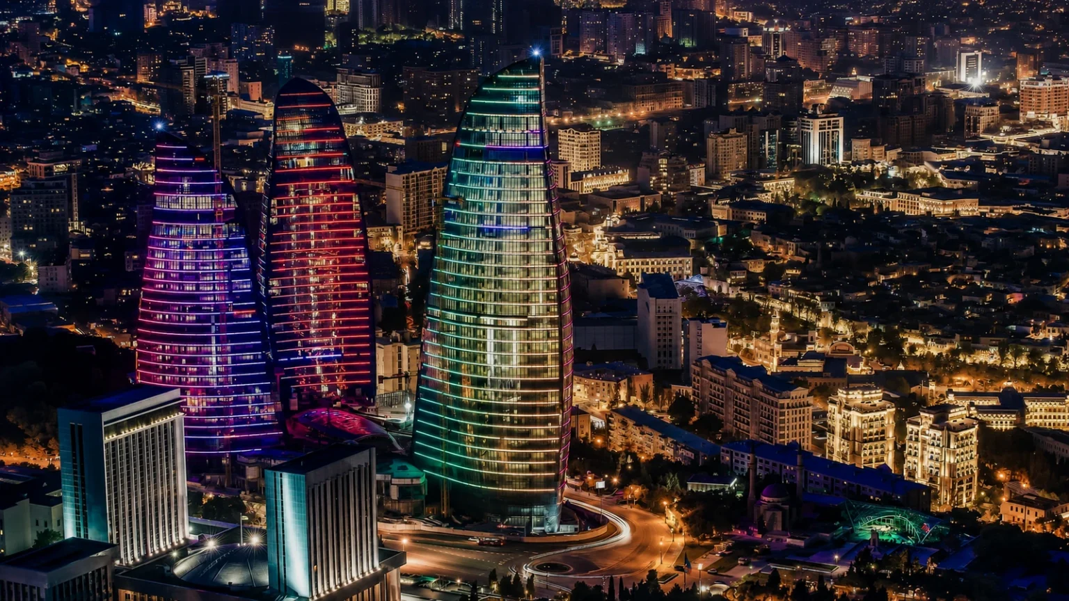 أبراج اللهب مضاءة ليلًا فوق أحياء باكو وشوارعها