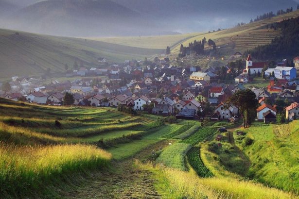 Slowakisches Dorf und Kirche zwischen grünen Feldern und sanften Hügeln
