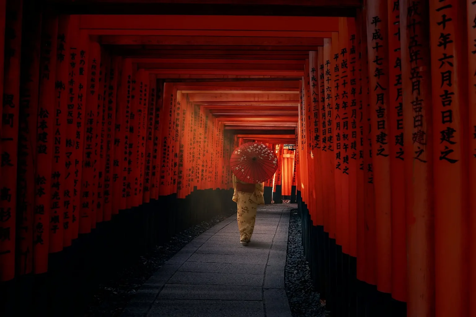 Artista con kimono y sombrilla roja en un entorno tradicional de Kioto