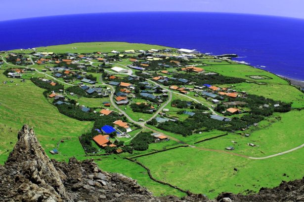 El cono volcánico y el asentamiento costero de Tristán de Acuña bajo un cielo nublado del Atlántico Sur