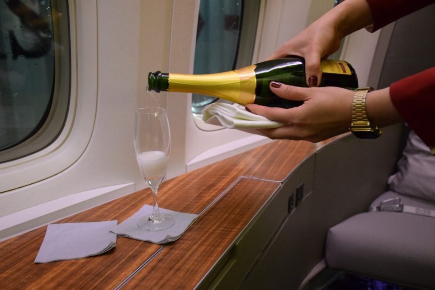 Membre d’équipage servant une boisson dans une cabine aérienne haut de gamme