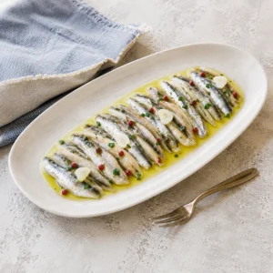 Anchois marinés grecs disposés à plat avec ail