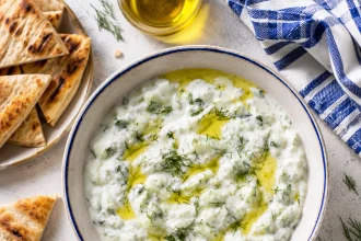 Vue carrée d’un tzatziki épais dans un bol bordé de bleu
