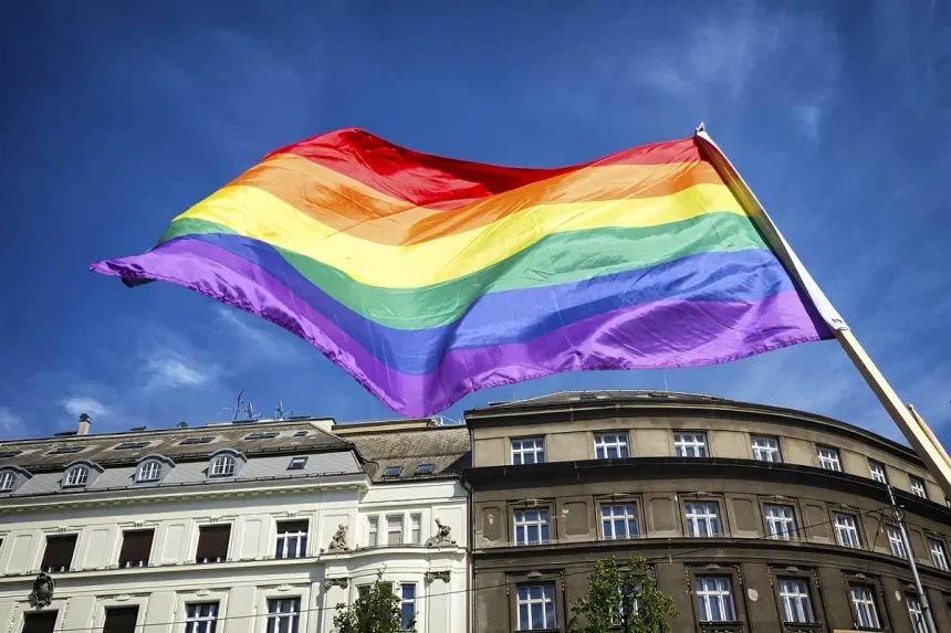 Grande parata Pride con bandiere arcobaleno e folla nelle strade