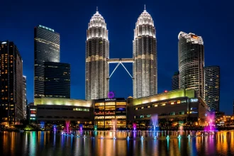 夜のクアラルンプールで輝くペトロナスツインタワーと噴水