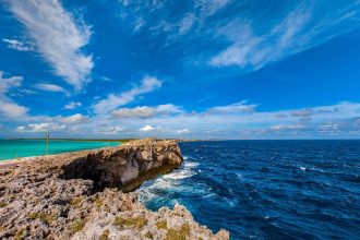 グラス・ウィンドウ・ブリッジの細い石灰岩地形を挟み、明るいBight of Eleutheraと濃い大西洋が並ぶ景観