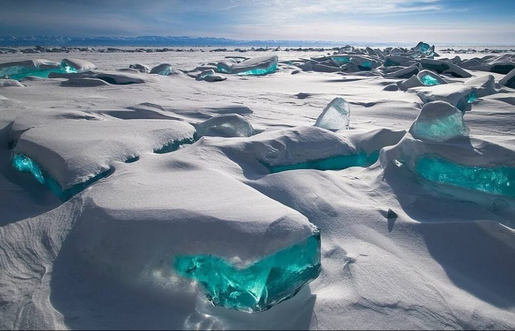 山々に囲まれたロシア・バイカル湖の広い青い湖面と湖岸景観