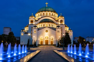 밤하늘 아래 조명된 베오그라드 성 사바 대성당과 푸른 분수