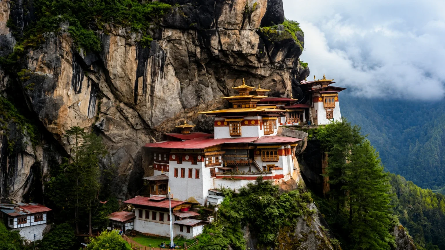 Paro Taktsang-klooster tegen een steile rotswand boven een beboste vallei