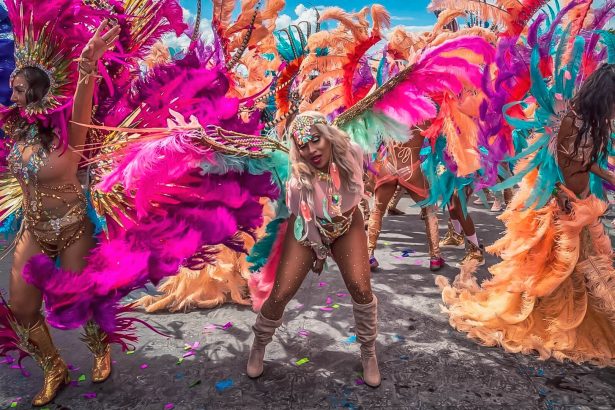 Masqueraders in felgekleurde kostuums met veren tijdens het Carnaval van Port of Spain