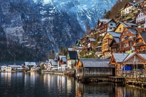 Huizen aan het meer en een kerktoren in Hallstatt onder steile groene bergen