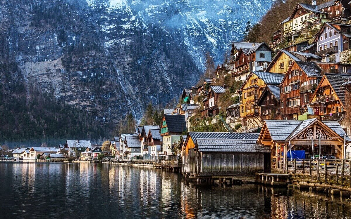 Huizen aan het meer en een kerktoren in Hallstatt onder steile groene bergen