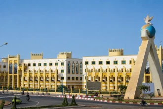 Монумент с голубем перед административным зданием и дорогой в Мали