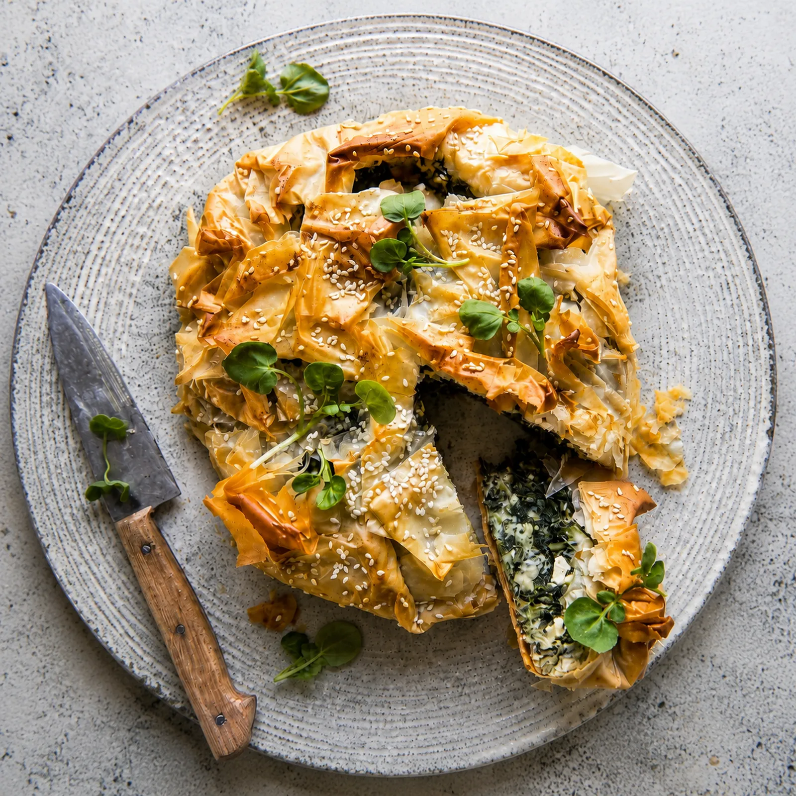 Okrugla spanakopita sa duboko zlatnim naboranim korama