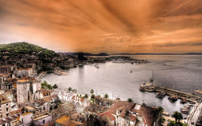 Mediteranski obalni grad sa svetlim zgradama i plavim morem