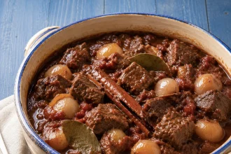 Gust grčki stifado sa velikim komadima govedine i celim glavicama sitnog luka u tamnom sosu od paradajza i vina